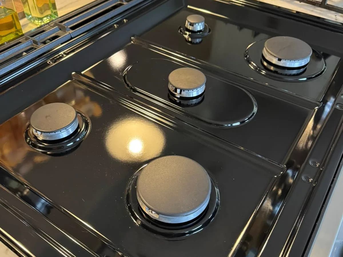 the same black gas stovetop with the surface and burner area cleaned after professional house cleaning